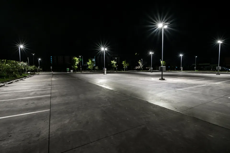 Asphalt parking lot at night with bright lights